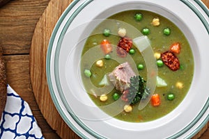 Hearty traditional Dutch pea soup with smoked sausage, rye bread and bacon. Or: `erwtensoep met rookworst, roggebrood en