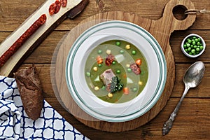 Hearty traditional Dutch pea soup with smoked sausage, rye bread and bacon. Or: `erwtensoep met rookworst, roggebrood en