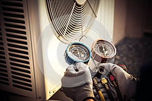 Heat and Air Conditioning, HVAC system service technician using measuring manifold gauge checking refrigerant and filling