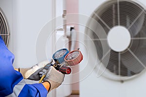 Heat and Air Conditioning, HVAC system service technician using measuring manifold gauge checking refrigerant and filling