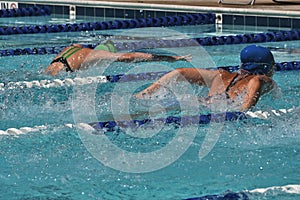 A heat of butterfly swimmers racing at a swim meet