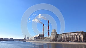 Heat electric plant and smoke from smoke stacks against blue sunny sky. 4K shot