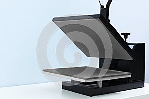 Heat press machine on table against light photo