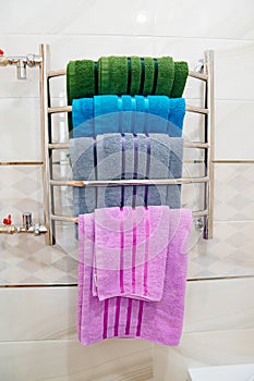 heated towel rail with multi-coloured towels in the bathroom.