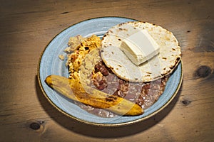 Heated traditional Colombian breakfast - Beans, egg, arepa, cheese and fried plantain photo