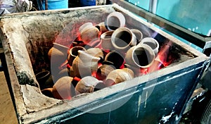 Heating clay pots in coal to make tea