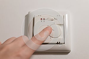 Heating control in the house.Heating the house with warm floors.Hand close-up turns on the floor heating. Smart home