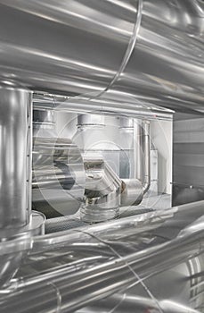 Heating and cooling pipe system with exhaust silencer in a heating plant