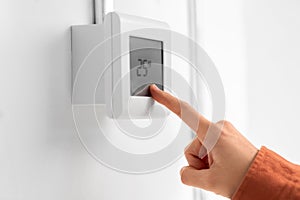 hand setting room temperature on sensor at home