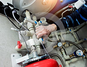 Heating engineer fixing modern heating system in boiler room.