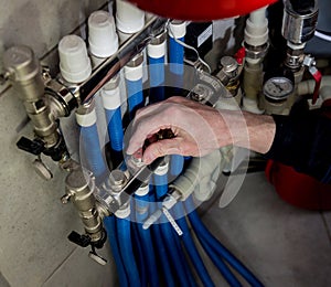 Heating engineer fixing modern heating system in boiler room.