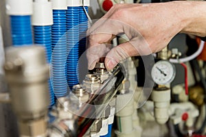 Heating engineer fixing modern heating system in boiler room.