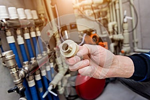 Heating engineer fixing modern heating system in boiler room.