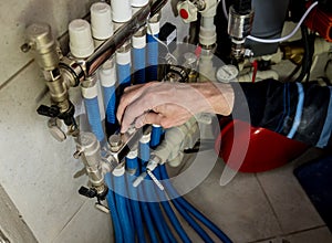 Heating engineer fixing modern heating system in boiler room.