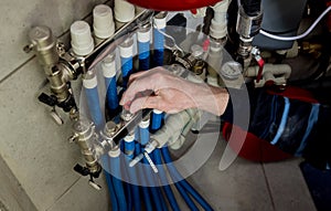 Heating engineer fixing modern heating system in boiler room.