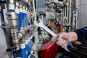 Heating engineer fixing modern heating system in boiler room.