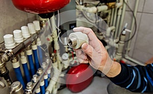 Heating engineer fixing modern heating system in boiler room.