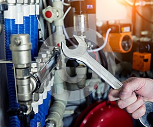 Heating engineer fixing modern heating system in boiler room.