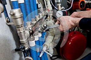 Heating engineer installing modern heating system in boiler room.