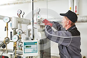 Heating engineer or plumber in boiler room installing or adjusting manometer