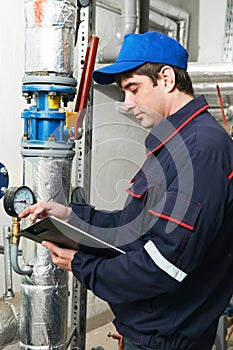 Heating engineer repairman in boiler room photo