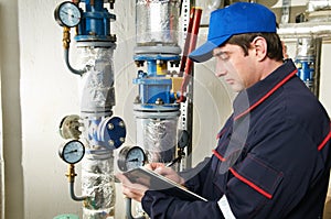 Heating engineer repairman in boiler room photo