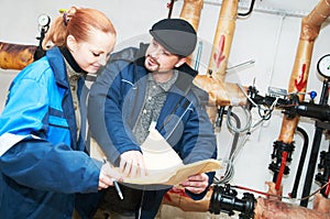 Heating engineers in boiler room