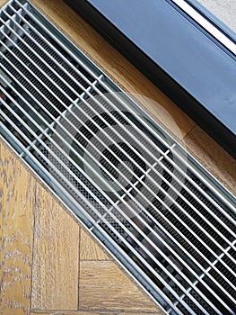 Heating grid with ventilation by the floor in hardwood flooring.