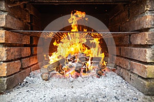 Heating the grill, huge burning flames over the grill, fire embers and sparks, burning wood coal