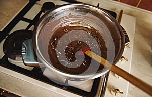 Heating and melting chocolate in a water bath before tempering it for preparing handmade chocolate desserts