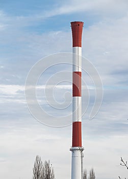 Heating and power station chimney in red and white stripes, without smoke, in an industrial part of the city