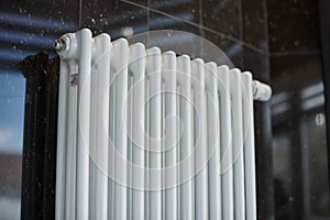 Heating radiator in office, close up. White heat exchangers. Iron aluminium steam radiator. Pipe pattern