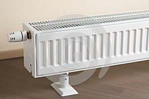 Heating radiator with thermostatic knob in the living room photo