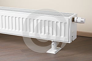 Heating radiator with thermostatic knob in the living room photo
