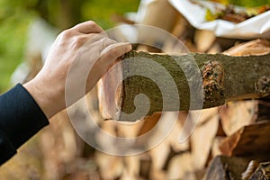 Heating season. Firewood.hands pulling a log from a woodshed. solid fuel.Male hands pulling a log from a woodshed