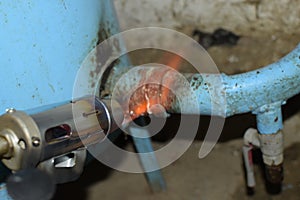 Heating a steel pipe with a blowtorch. The flame of a blowtorch