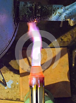 Heating a steel pipe with a blowtorch. The flame of a blowtorch