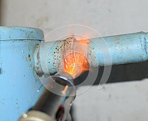 Heating a steel pipe with a blowtorch. The flame of a blowtorch