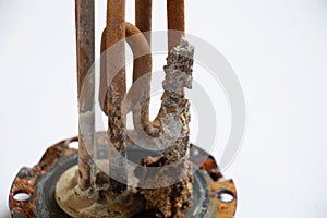 heating ten from a water heater after 8 years of operation broken on a white background, replacing an old ten from a