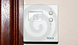 Heating thermostat on white wall photo