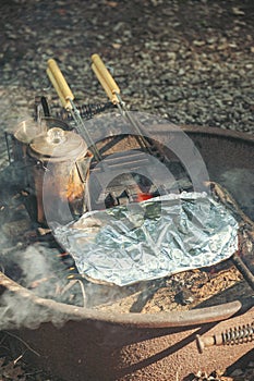 Heating water and cooking food over a campfire in the summer