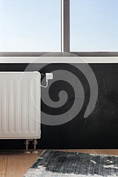 Heating white radiator with adjuster of warming in living room