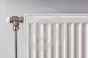 Heating white radiator with adjuster of warming in living room