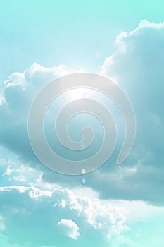 Heaven background. Clouds and sunshine. White clouds and sun rays in a light blue sky.Beautiful heavenly wallpaper in