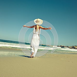 Heaven on earth. Rearview shot of a woman enjoying a carefree day at the beach.