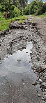 Heavily eroded road bed with stagnant water ponding, Cotacachi, Ecuador, andes, South America