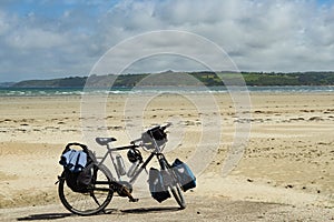 A heavily packed touring bicycle on a beach in Brittany, France.