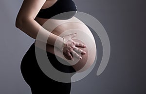 Heavily Pregnant Lady against Grey Background