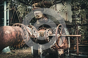 Heavily rusted pipes and pipes with peeling paint of an old disused derelict factory