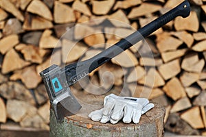 Heavy ax on the stump and protection gloves